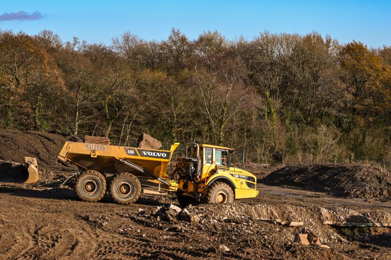 Dumper truck moving a load of soil on the site of a new housing development.