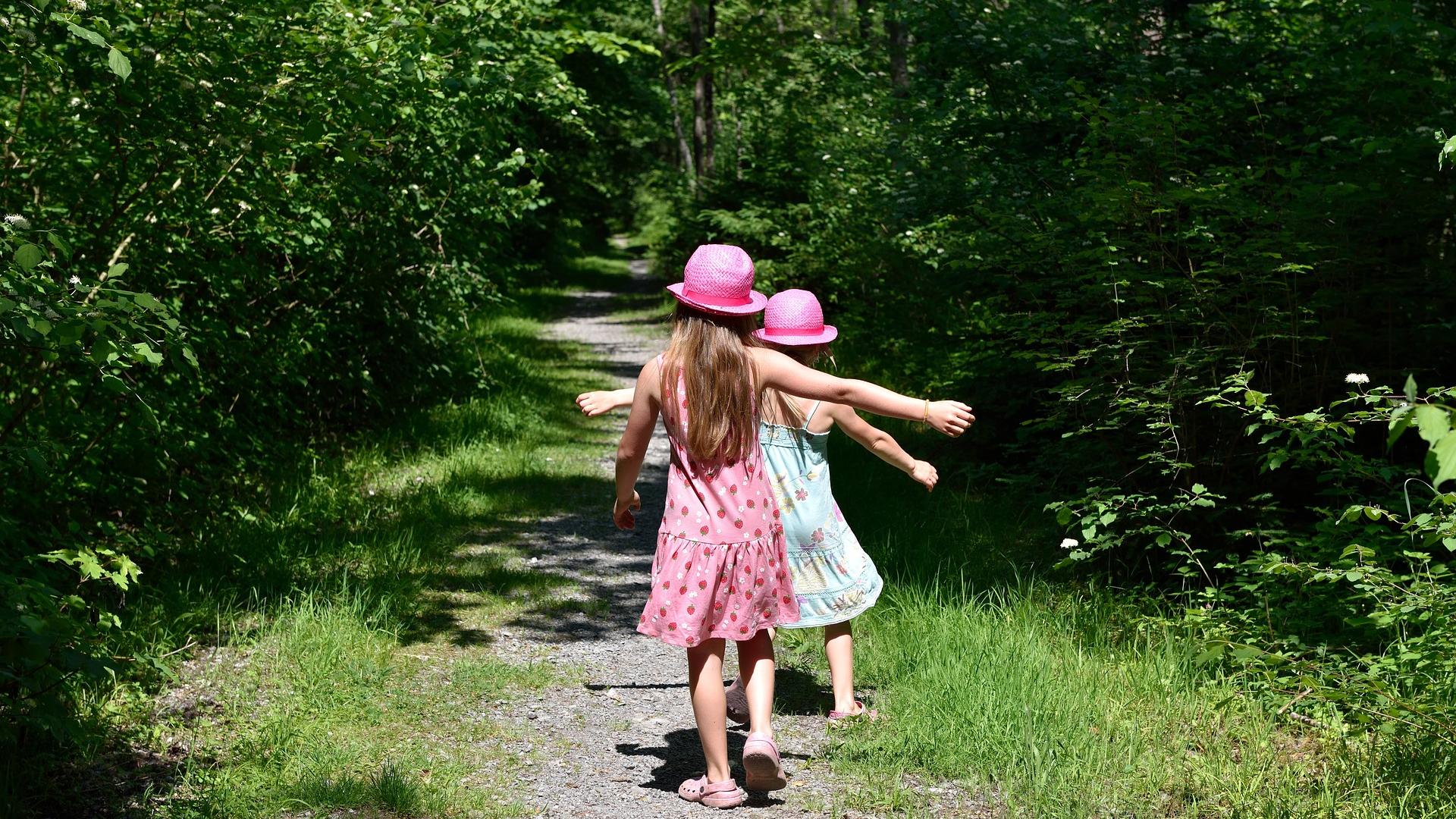 Children running down a lane in woods