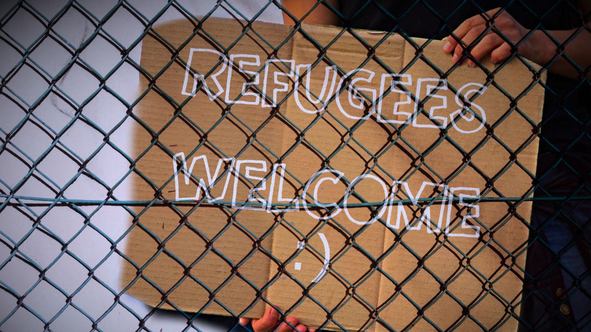 Refugees welcome notice held behind fence