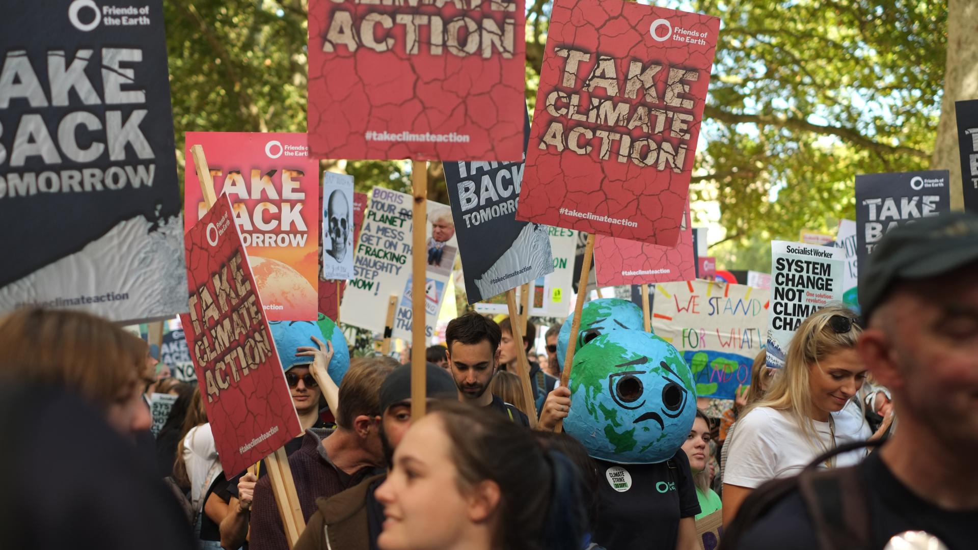 People with placards marching for climate justice in London