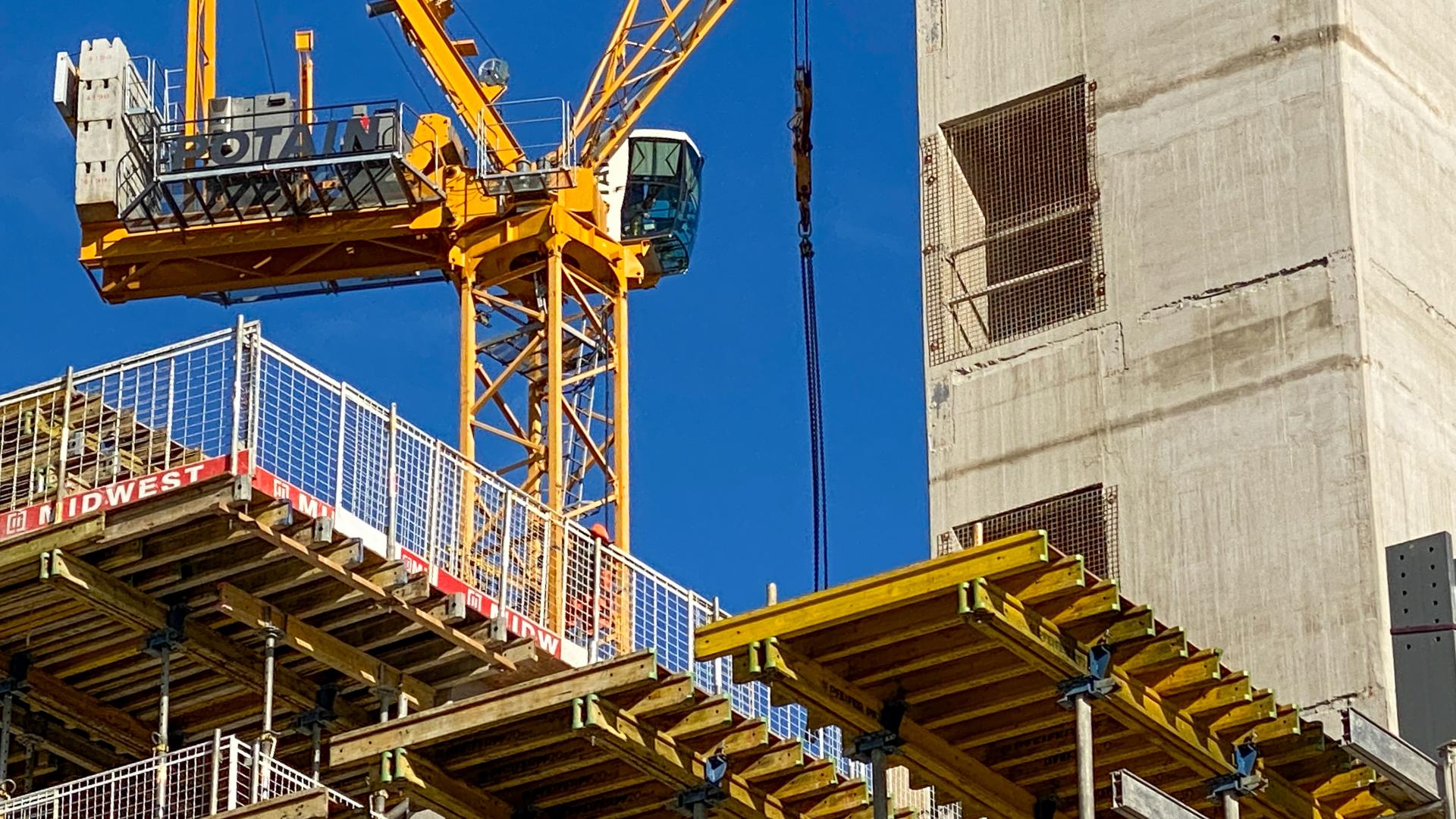 Tower crane alongside the construction of the lift shaft of a new office development in Cardiff city centre.