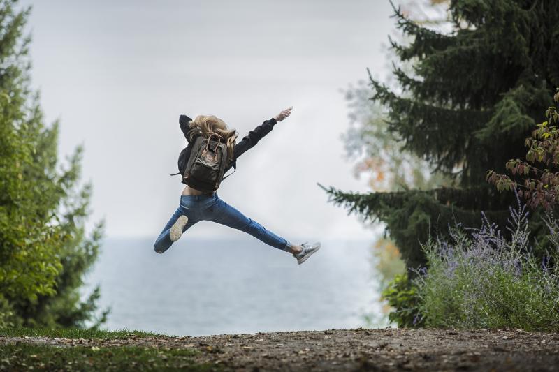 Woman in the wild leaping with happiness