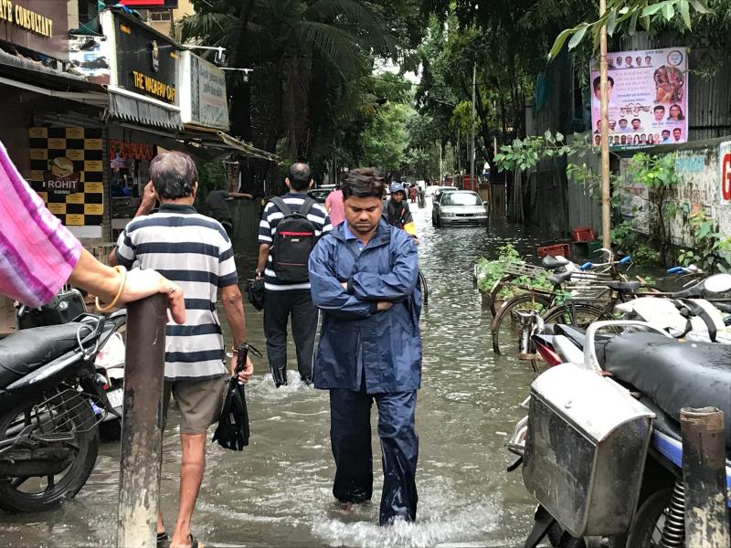 People in Asian country walking in flooded street