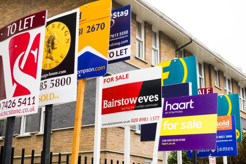 Row of For sale estate agent signs outside new house