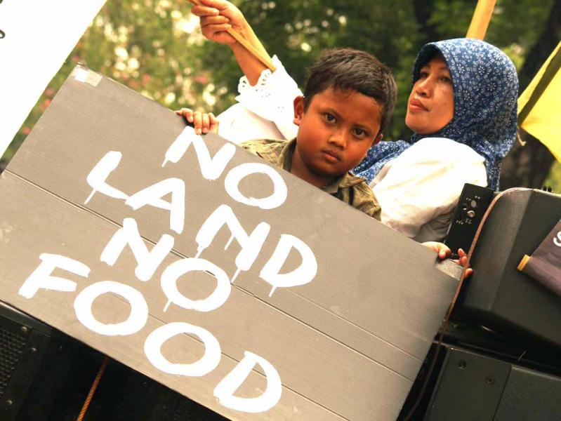 Woman and child holding placard "No Land No Food" on World Food Day march, Indonesia