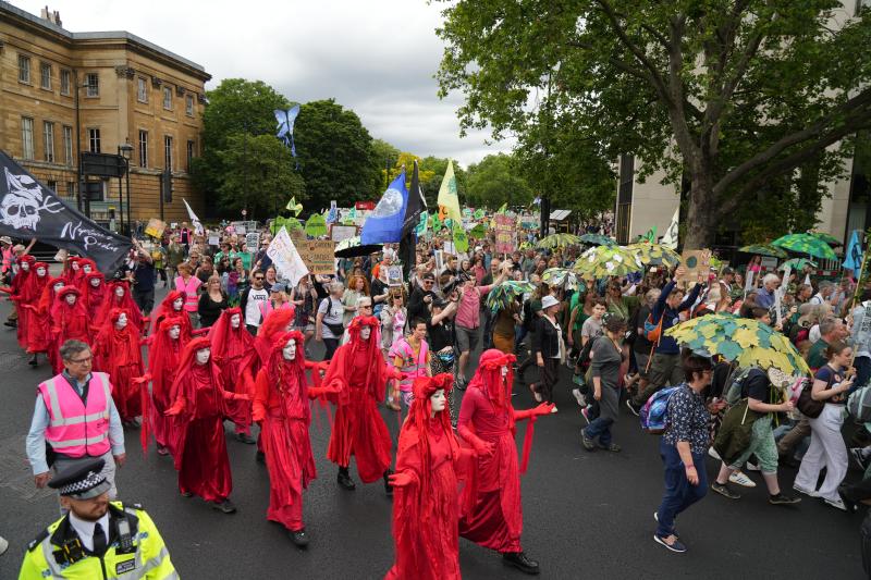 Restore Nature Now march 2024 - RED REBEL BRIGADE march past a police officer