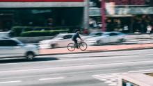 Man on bike with blurred traffic behind him