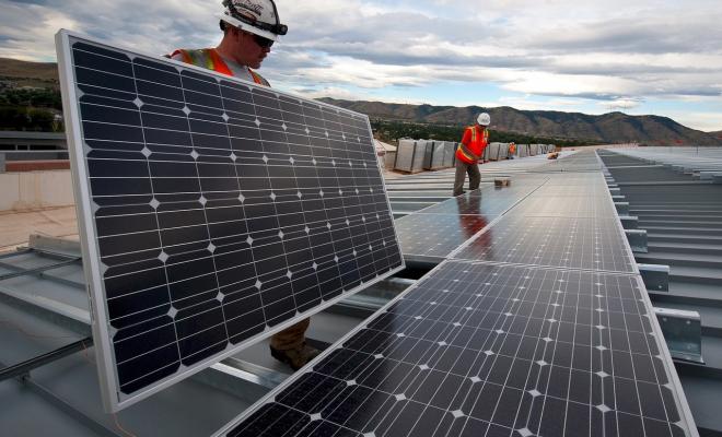 Men installing solar panels on roof