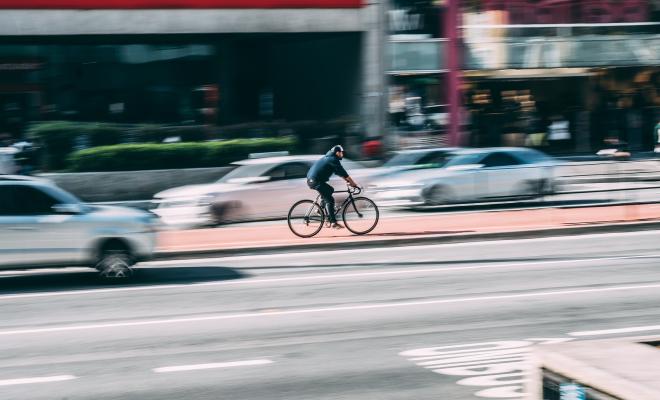 Man on bike with blurred traffic behind him