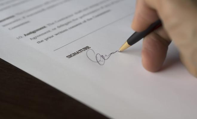 hand with pen signing an agreement