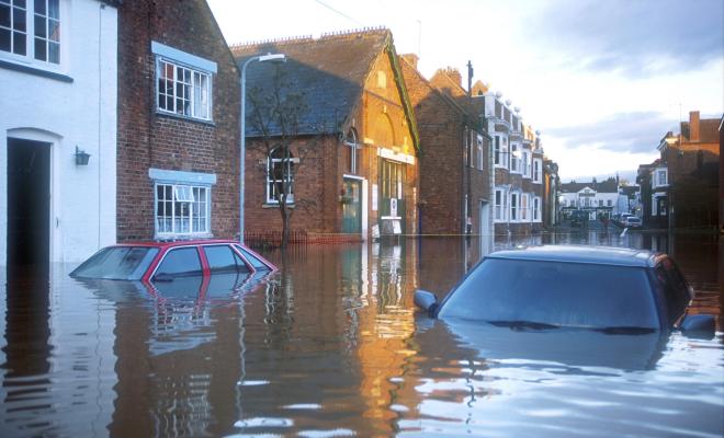 Submerged cars in flooded town with water at level of groundfloor windows