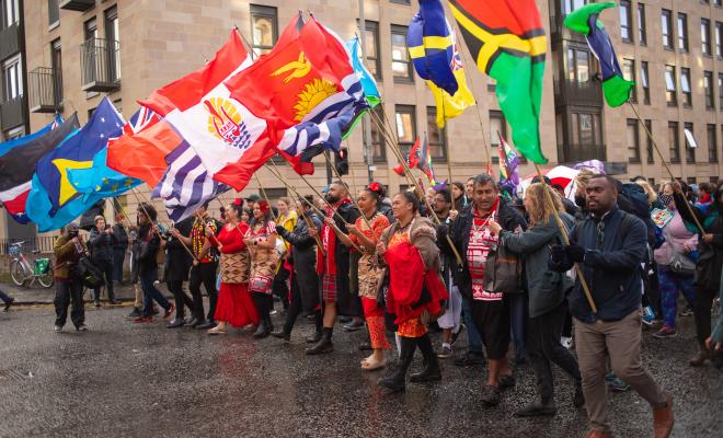 Members of 350 Pacific wave flags, marching at COP26.  Photos from the Global Day of Action during COP26 in Glasgow. FoEEWNI, FoES, FoE International and our groups were part of the Climate Justice bloc.